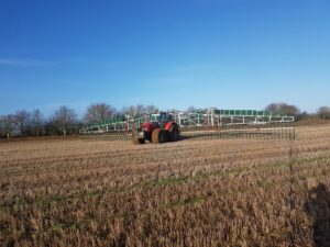 A tractor spreading digestate on the crops